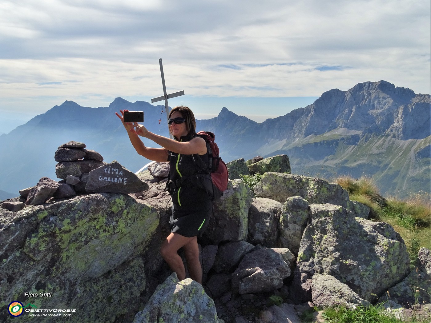 24  Alla croce della Cima delle galline (2131 m) con alle spalle la costiera da dx Arera-Valmora-Fop-Secco.JPG